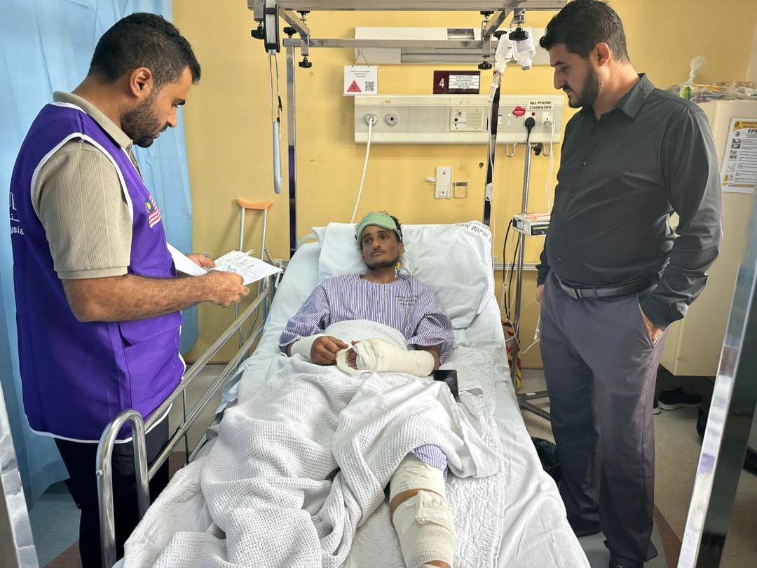 Ayoub di katil hospital selepas pembedahan, dengan balutan pada tangan kiri dan kakinya, dikunjungi oleh Dr. Ali Saleh