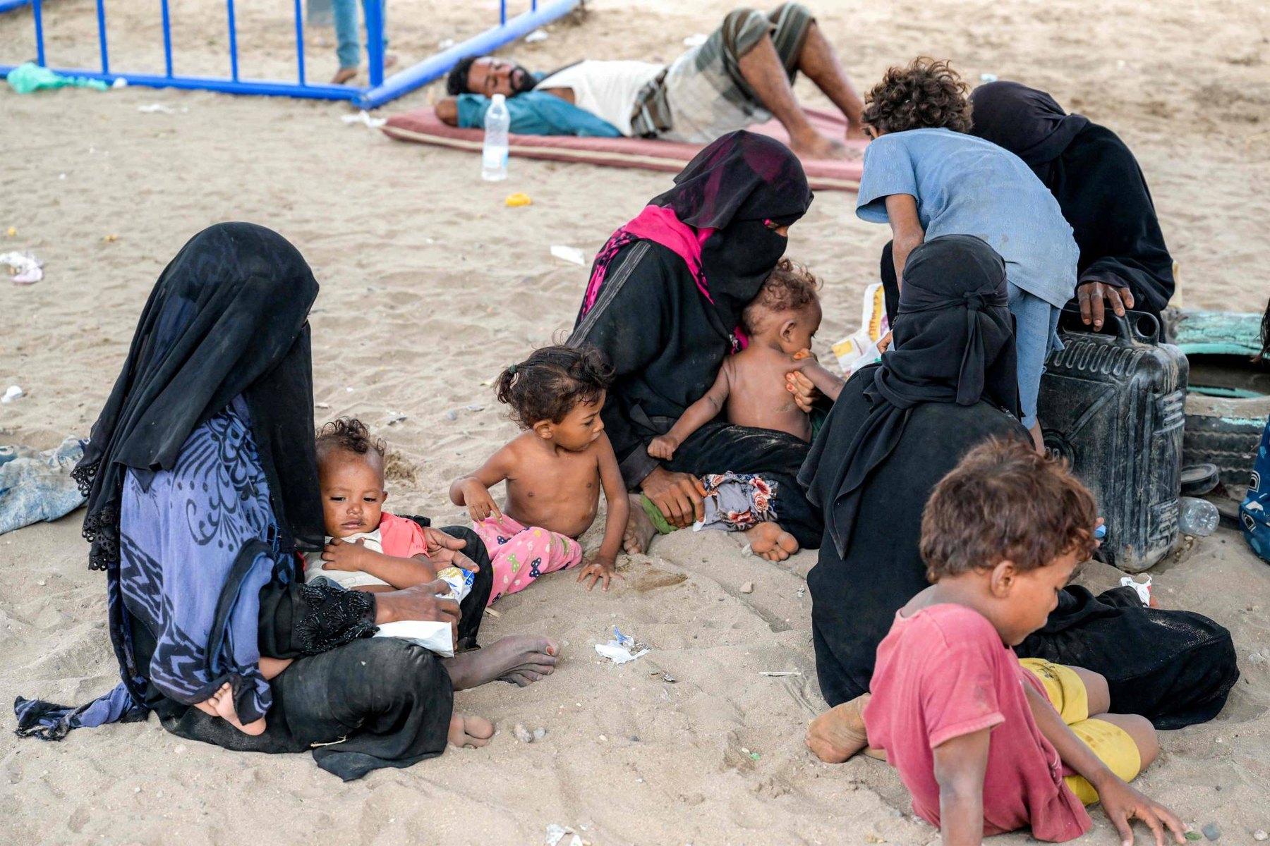 Families who arrived with nothing, waiting in the open. No tent, no bedding, no cooking pot.